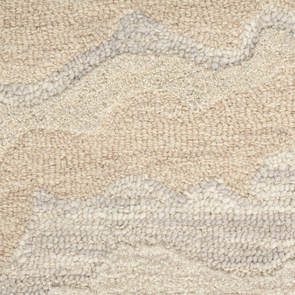 Beige and light gray abstract tufted rug with soft looped pile and wavy geometric pattern.