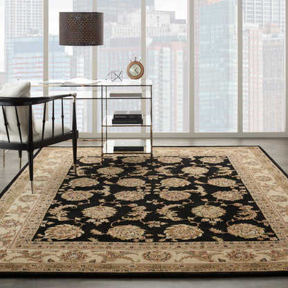 Ornate black and beige traditional oriental rug in a modern living room with glass desk, black chair, city skyline through large windows.