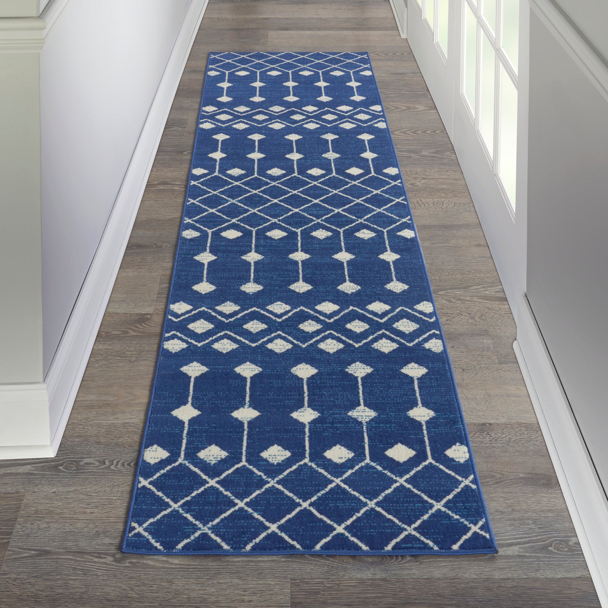 Navy blue woven hallway runner with white geometric diamonds and lattice pattern.