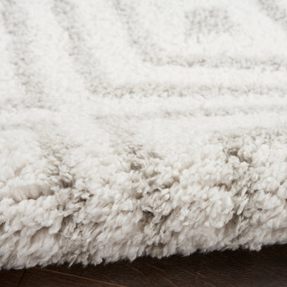 Ivory shag rug with ultra-soft, thick plush pile and visible edge on dark wood floor.