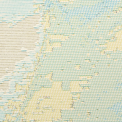 Woven rug in pale blue with cream-yellow floral motifs and subtle grid texture; coastal casual.