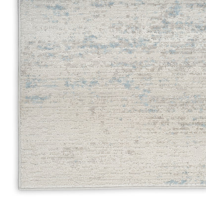 Cream-beige area rug with subtle blue accents, distressed pattern, low-pile, rectangular.