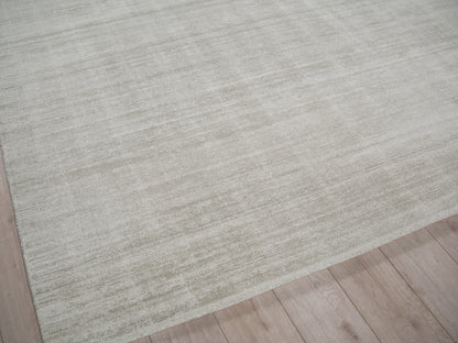 Beige cream rectangular area rug with soft woven texture on light wooden floor.