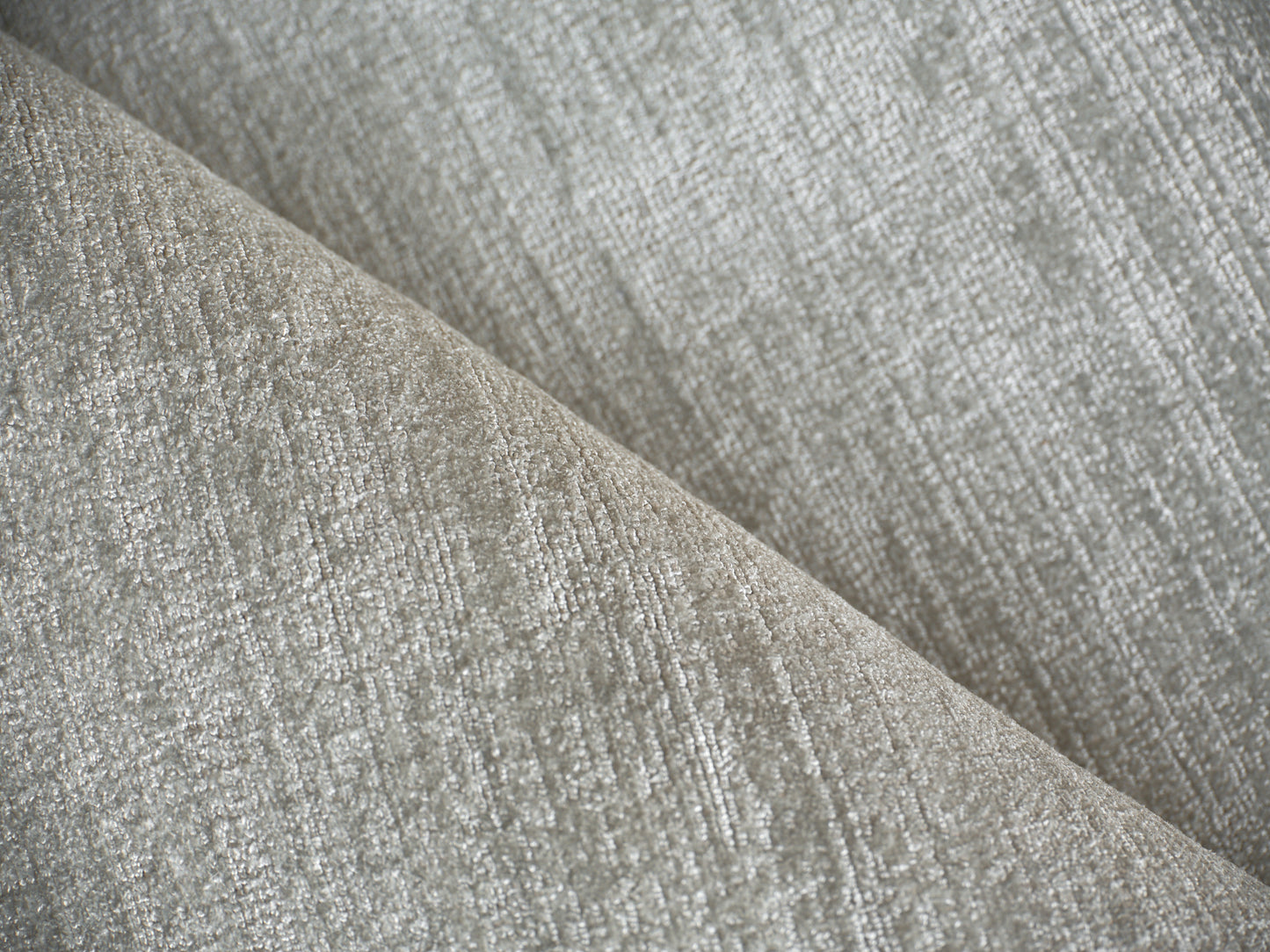 Gray textured upholstery fabric close-up with a woven pattern and soft neutral tones.