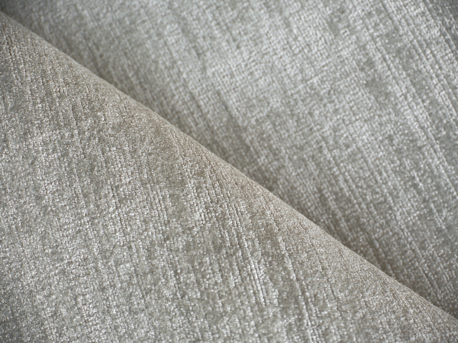 Gray textured upholstery fabric close-up with a woven pattern and soft neutral tones.