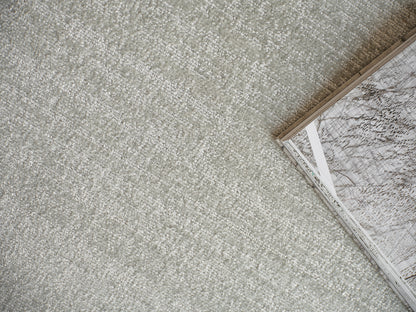 Soft gray textured carpet with a corner-open magazine featuring marble-patterned pages.