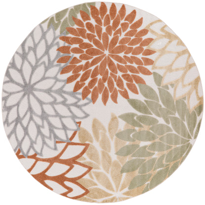 Circular area rug with large multicolor floral petals in orange, gray, sage green and beige on cream background.
