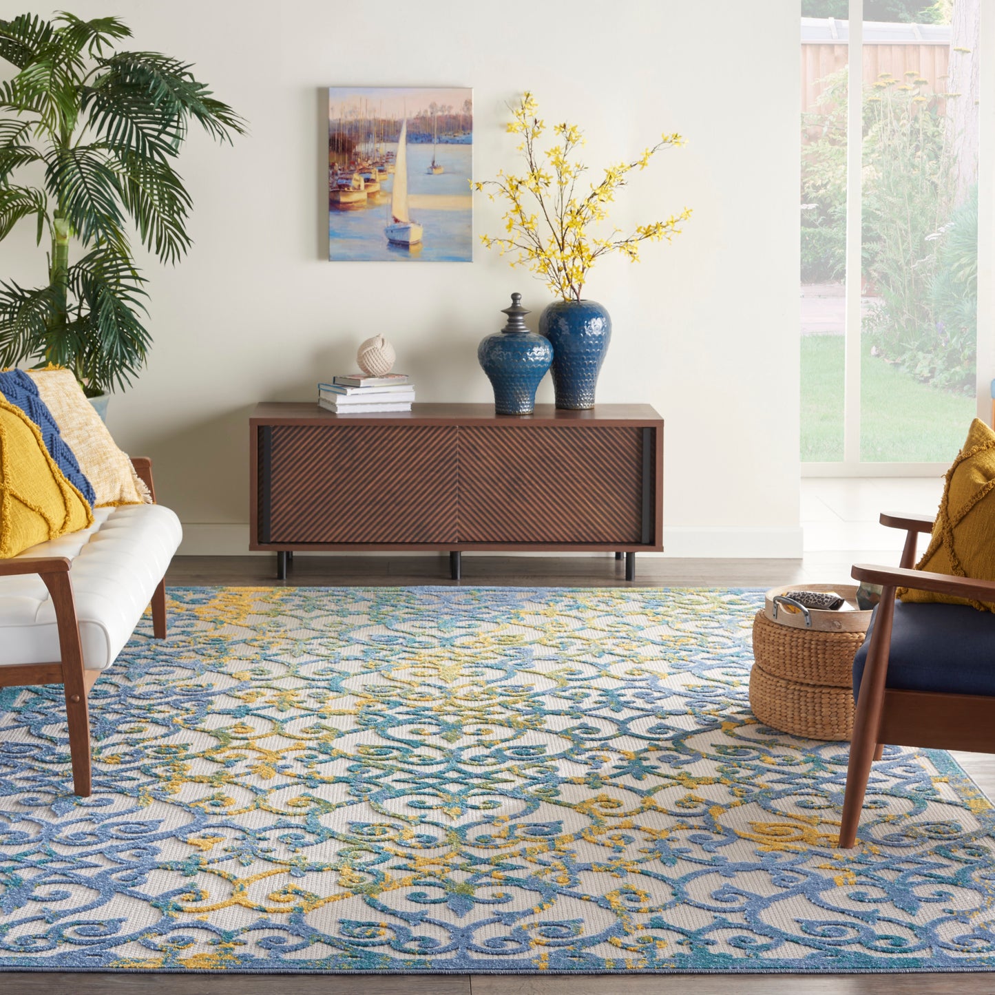 Mid-century living room with blue-yellow rug, white sofa, mustard cushions, dark sideboard, blue vases, yellow branch