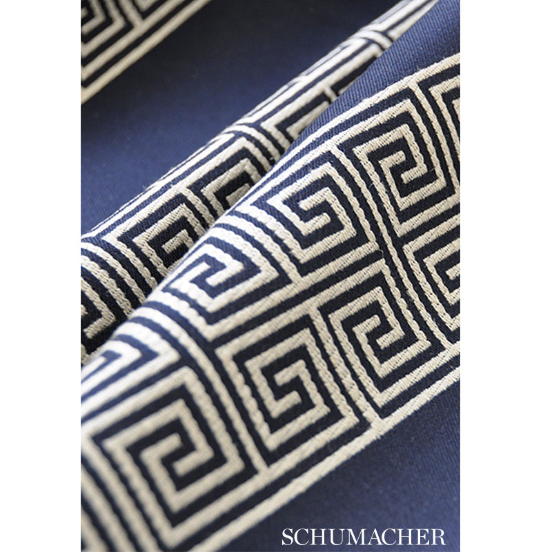 Navy blue fabric with a white Greek key geometric border; Schumacher fabric swatch.