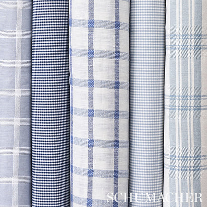 Rolled navy and white cotton check patterned woven fabrics; suitable for apparel or home decor.