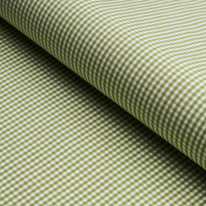 Green and white gingham cotton fabric rolled, close-up checkered weave.