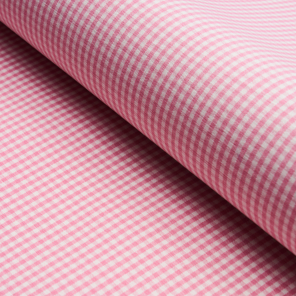 Pink and white gingham fabric, close-up of rolled edge with tiny checks.
