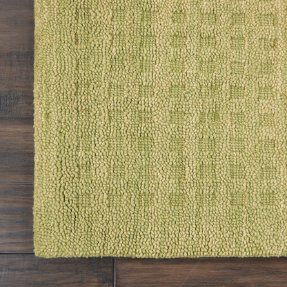 Olive-green loop-pile rug with dense shaggy texture on wooden floor; modern, rectangular, soft underfoot.
