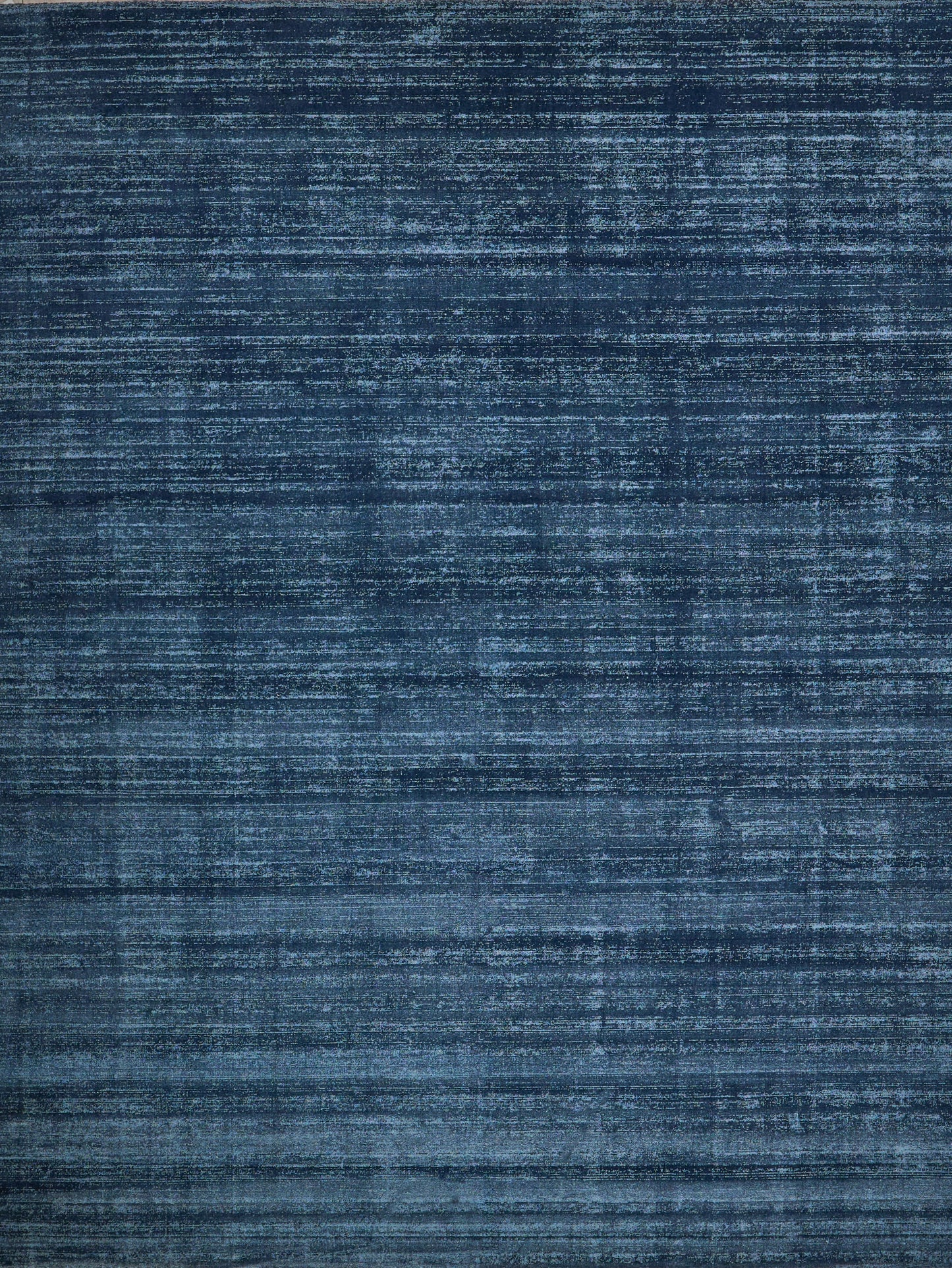 Navy blue distressed rug with faded horizontal streaks and vintage texture.