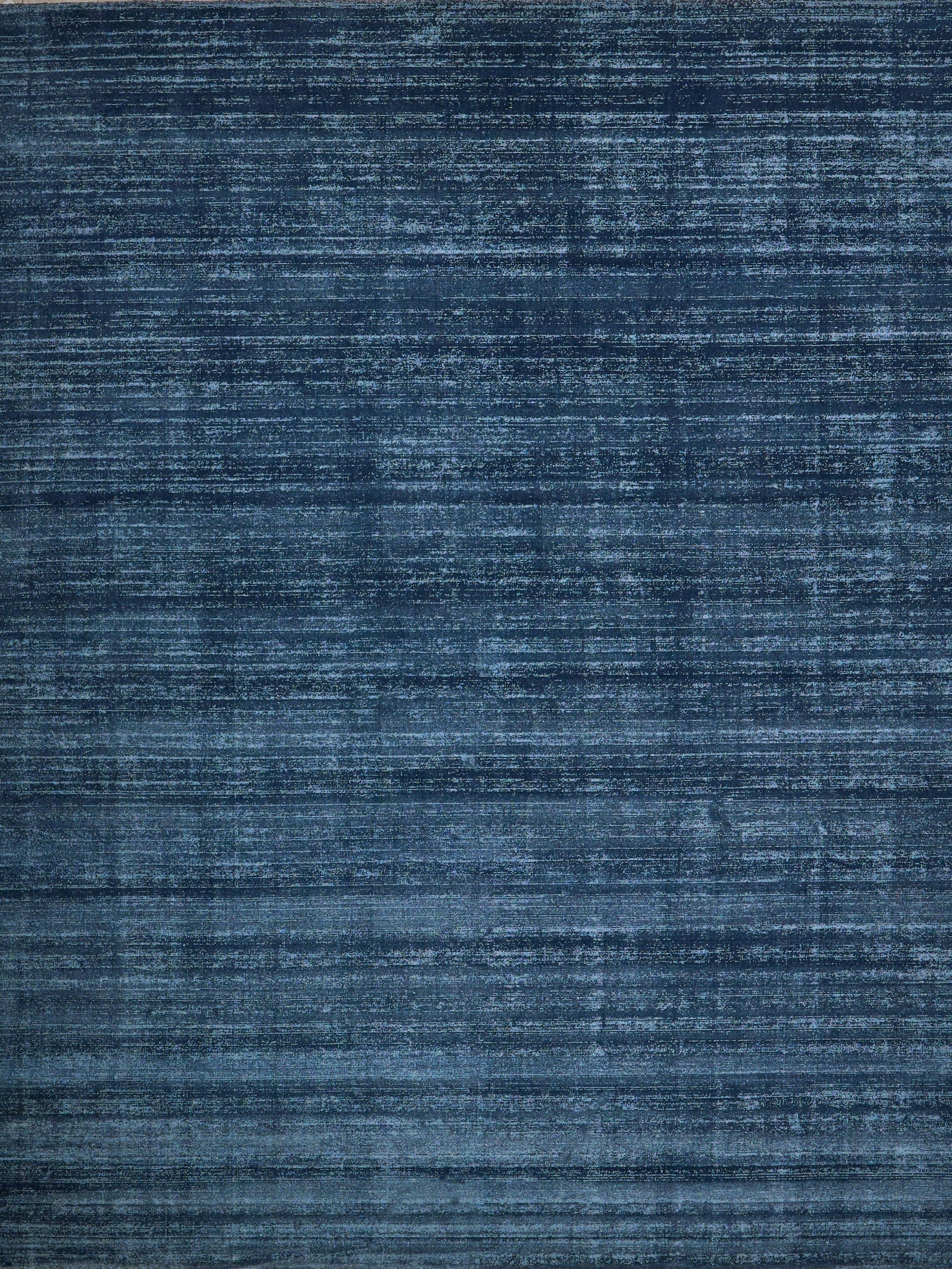 Navy blue distressed rug with faded horizontal streaks and vintage texture.