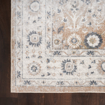 Beige and cream oriental-style rug with blue floral motifs and border laid on dark wood floor.