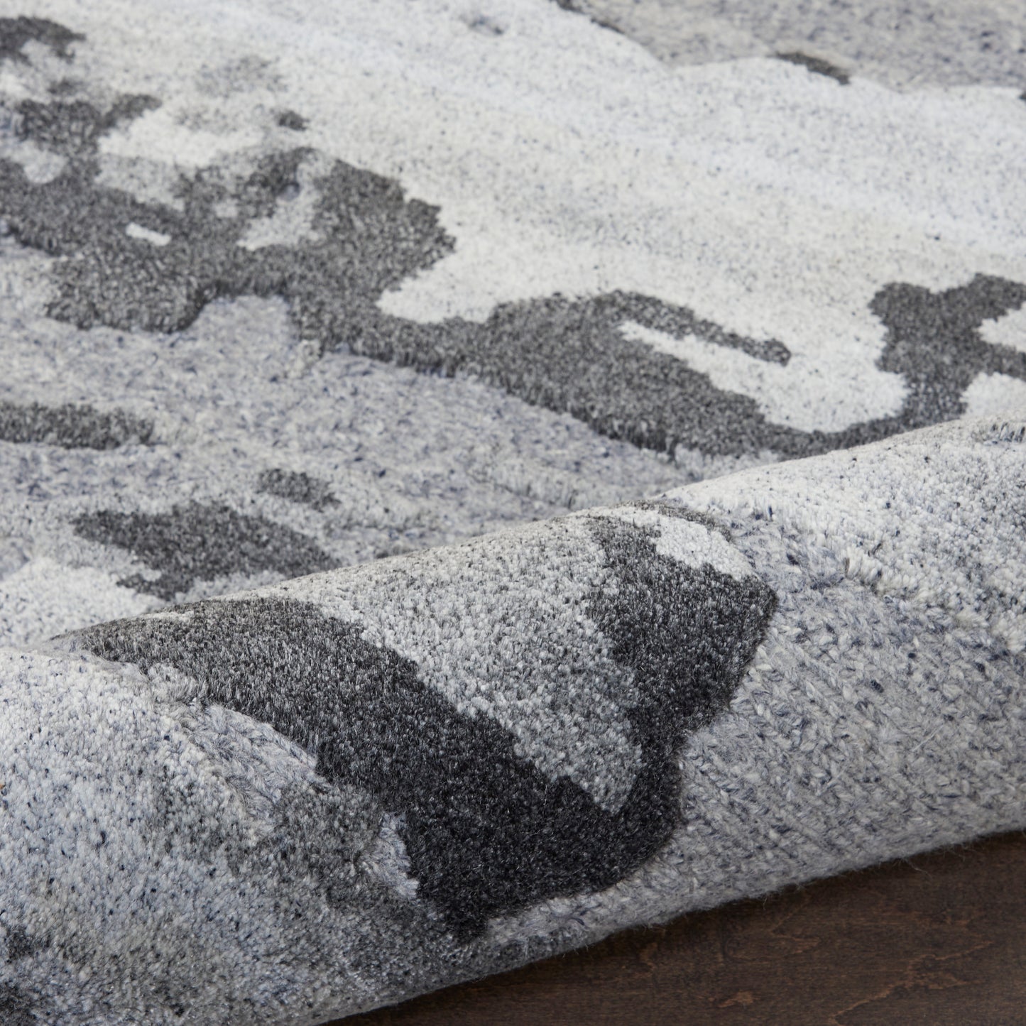 Soft gray and charcoal abstract area rug with a dense plush pile and geometric pattern.