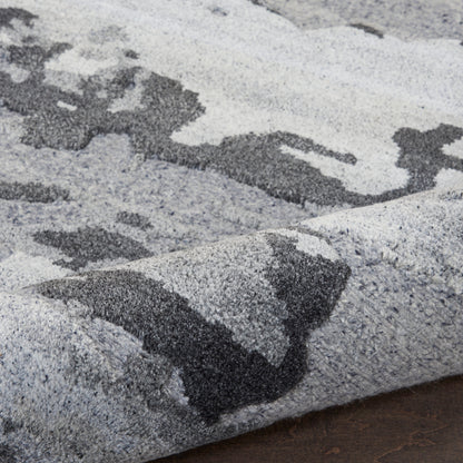 Soft gray and charcoal abstract area rug with a dense plush pile and geometric pattern.