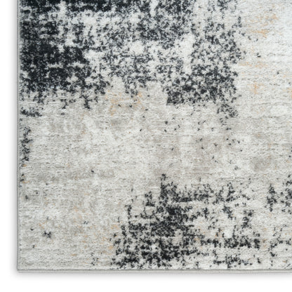 Rectangular abstract distressed area rug in gray, cream, beige and black with a plush pile.
