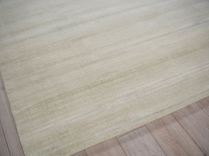 Beige area rug with soft texture and subtle horizontal pattern on light wooden floor.