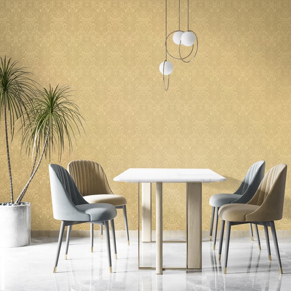 Gold brocade wallpaper (wallcovering) in a dining nook; white square table, beige/gray upholstered chairs with gold legs, pendant lights, palm plant.