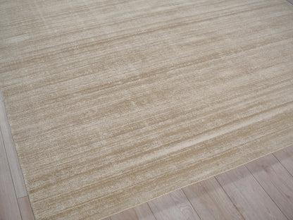 Beige textured area rug with subtle cream stripes on a light wood floor.