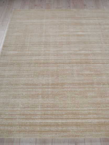 Beige rectangular area rug with subtle brushed texture, modern neutral style on light wood floor.