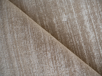Tan tweed fabric upholstery with diagonal fold, textured woven surface.