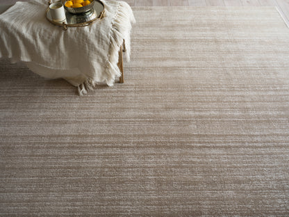 Beige woven area rug with subtle horizontal stripes; soft, textured pile for a cozy modern living room.