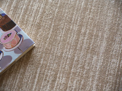 Open illustrated book with pink teacup artwork on pastel page, resting on beige striped carpet.