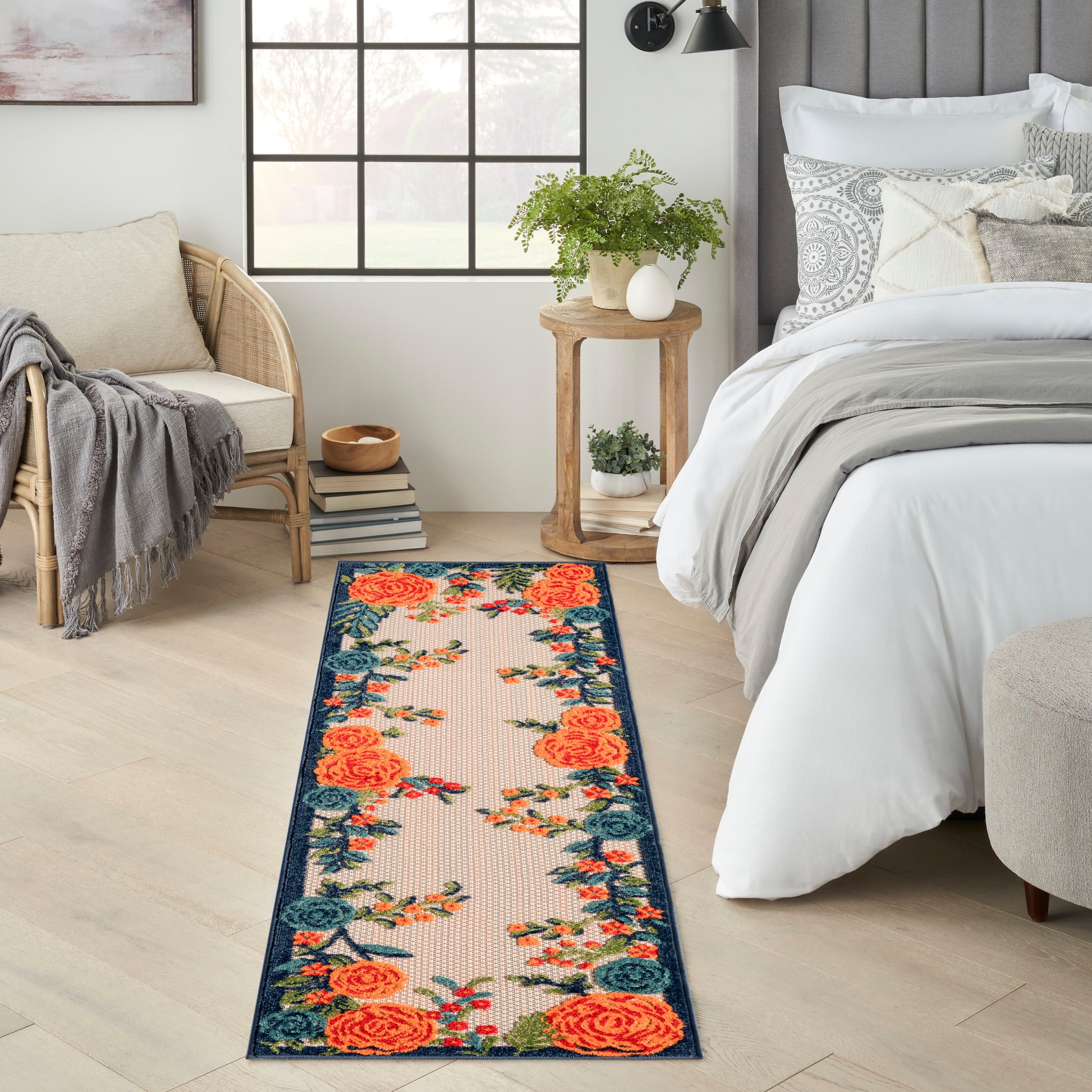 Long floral outdoor runner rug with orange roses and a teal border.