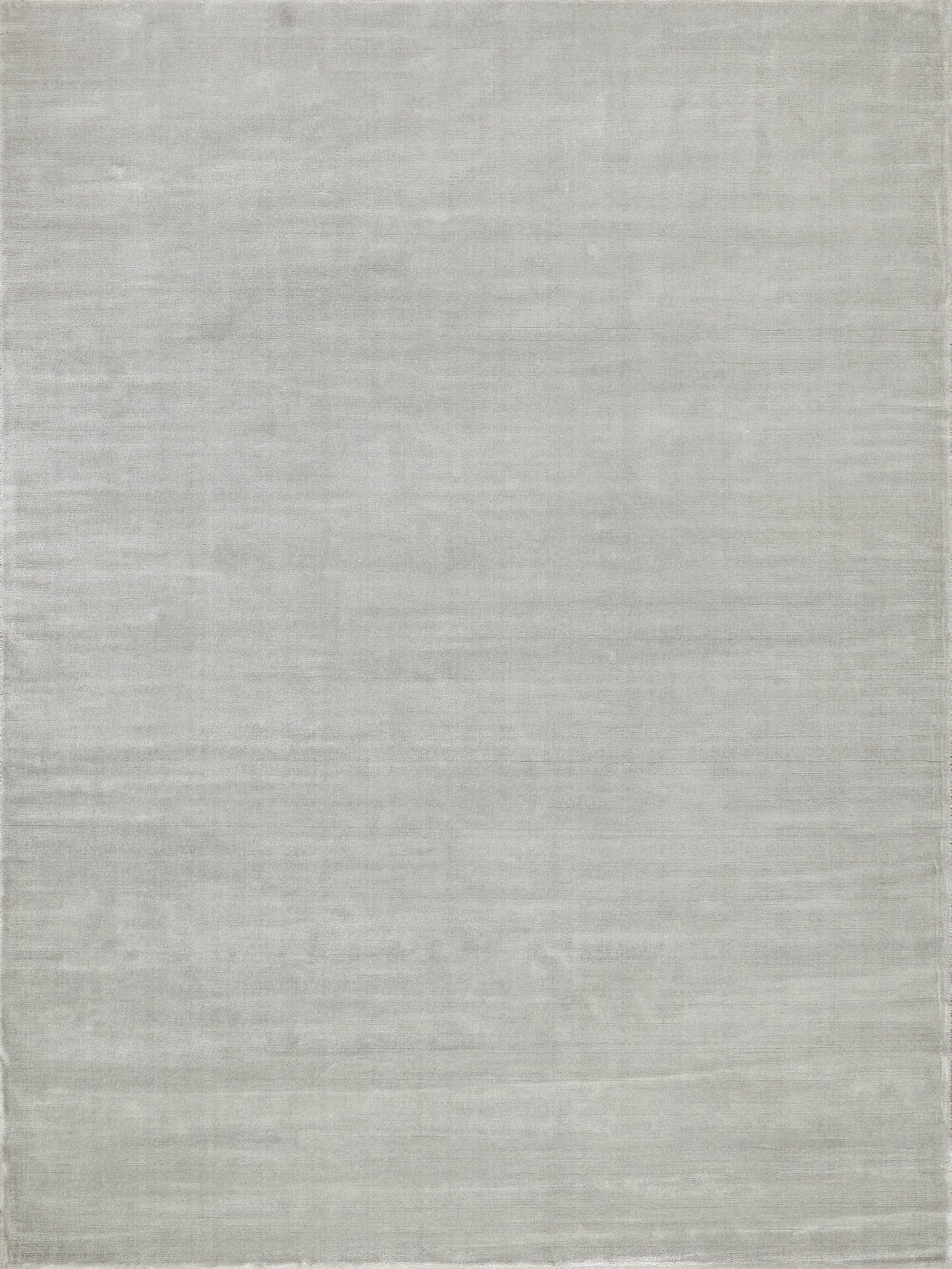 Light gray rectangular rug with subtle woven texture and a soft, minimalist look.