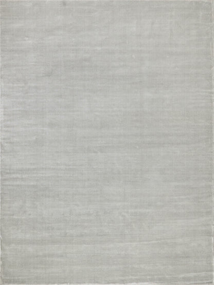 Light gray hand loomed rug with subtle heathered texture; rectangular and minimalist for living spaces.