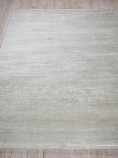 Light gray area rug with soft, washed texture on a wood floor.