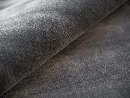 Dark charcoal gray rug close-up with soft nap and folds.