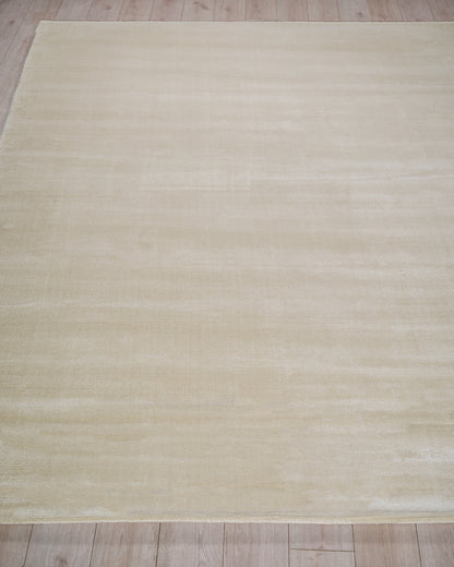 Cream-beige rectangular rug with subtle tonal stripes on a light wood floor.