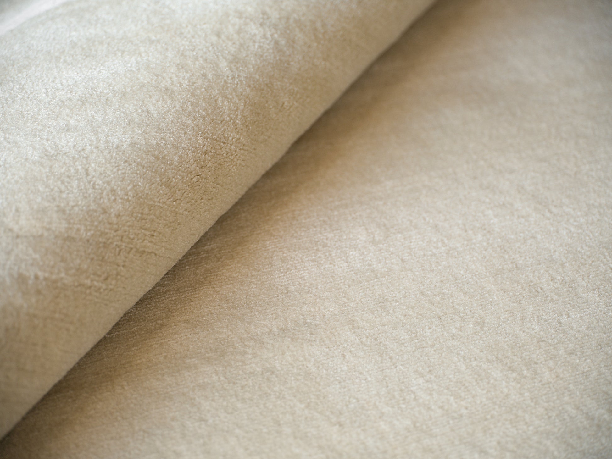 Beige suede-like rug close-up with soft nap and folded edge; 4' x 6'.