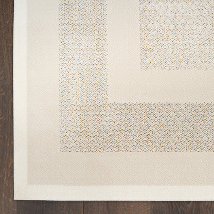 Beige area rug with a thick cream border and a textured geometric weave, laid on dark wood floor.
