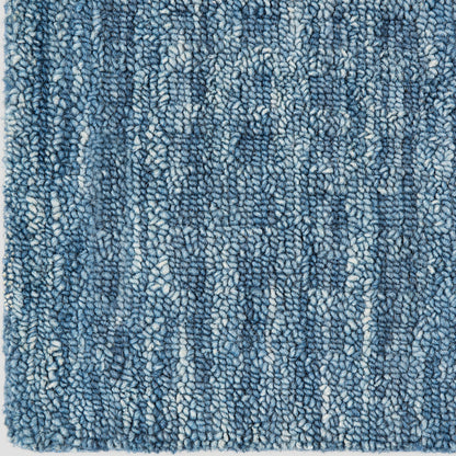 Blue textured shag rug with dense looped pile and subtle white flecks; cozy, modern Berber-inspired style.