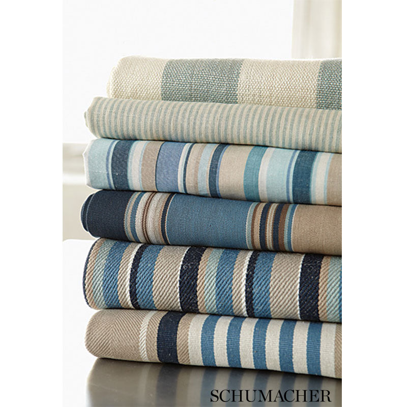 Stack of striped woven blankets in blue, beige and cream tones; soft, decorative throws.