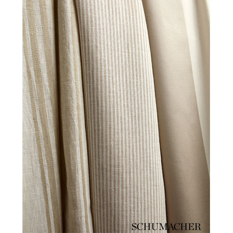 Beige fabric swatches in vertical folds: striped corduroy, textured linen and smooth solid weaves.