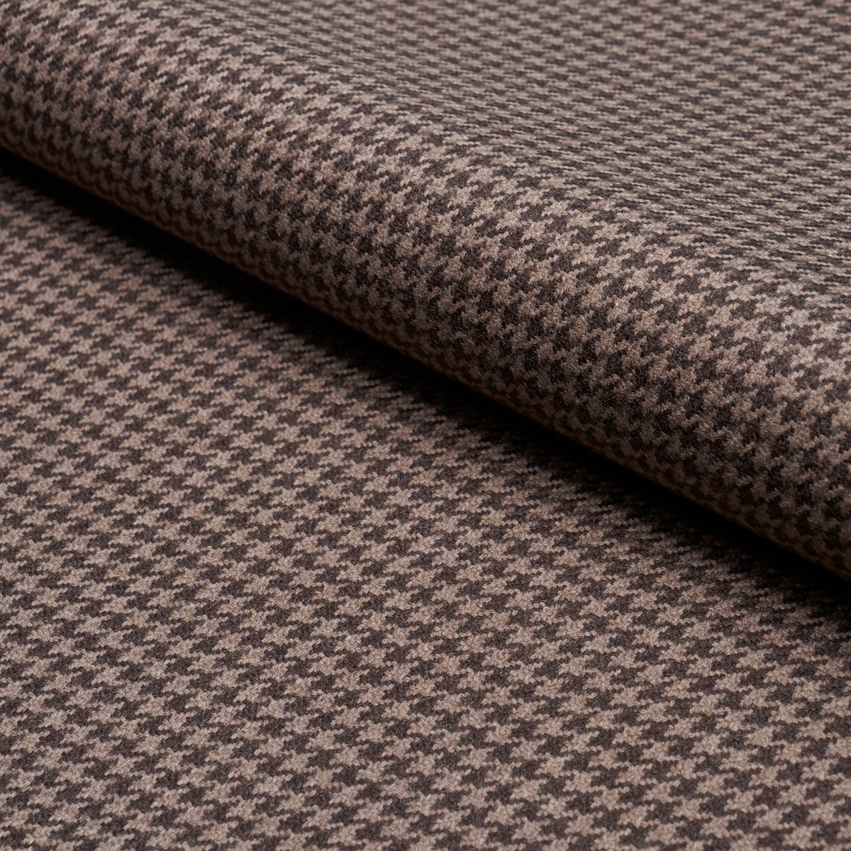Brown and tan houndstooth fabric, folded, wool-like texture.