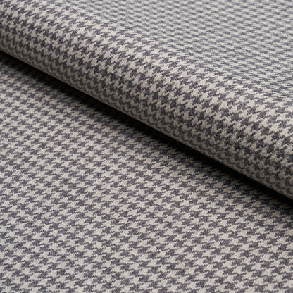 Grey & white houndstooth wool blend fabric, rolled bolt; classic tailored textile for coats, jackets, or upholstery.
