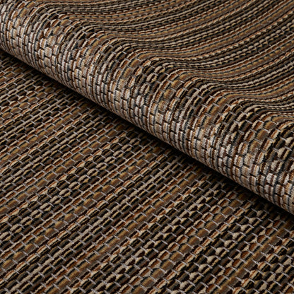 Brown and beige woven rug with a textured striped pattern, rolled at the edge to show chunky weave.