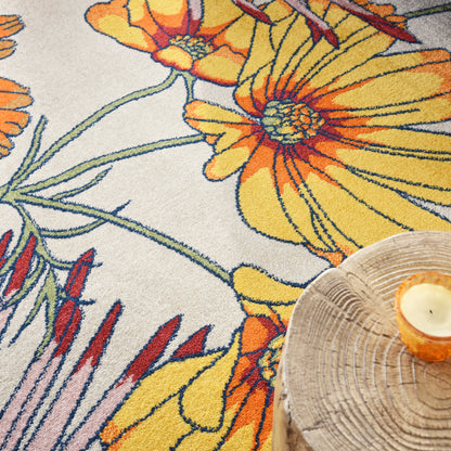 Close-up of floral rug with bright yellow-orange flowers, green stems on cream background, plus wooden candle tray.