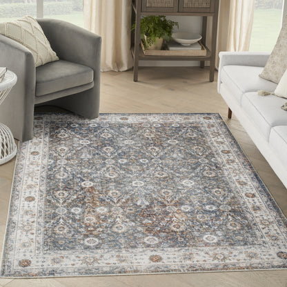 Blue-gray and ivory traditional rug with distressed floral medallions and border in a light living room.