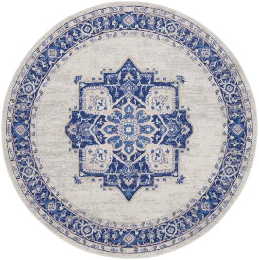 Round blue and ivory rug with Persian-inspired medallion, distressed vintage look, ideal for living room decor.