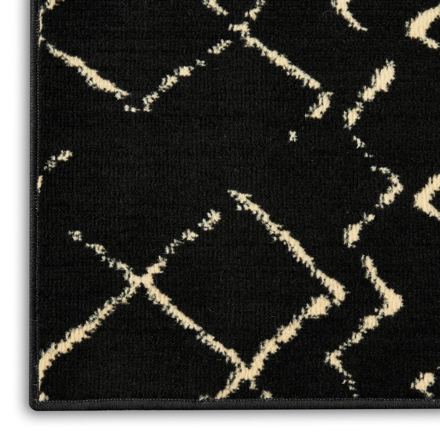 Black rug with cream diamond lattice pattern; woven tufted texture and slim black border.