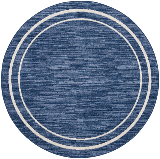 Blue round rug with cream concentric rings and a textured weave.