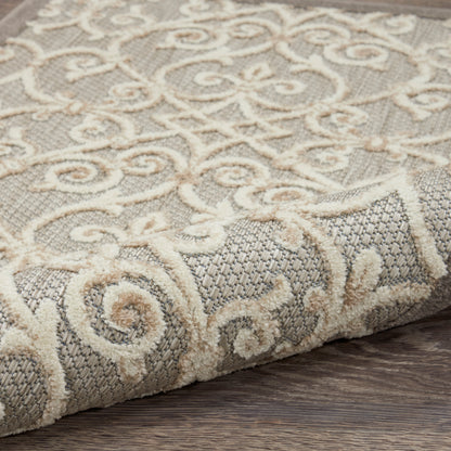Cream damask pattern rug on gray woven background, partially rolled at edge on wood floor.